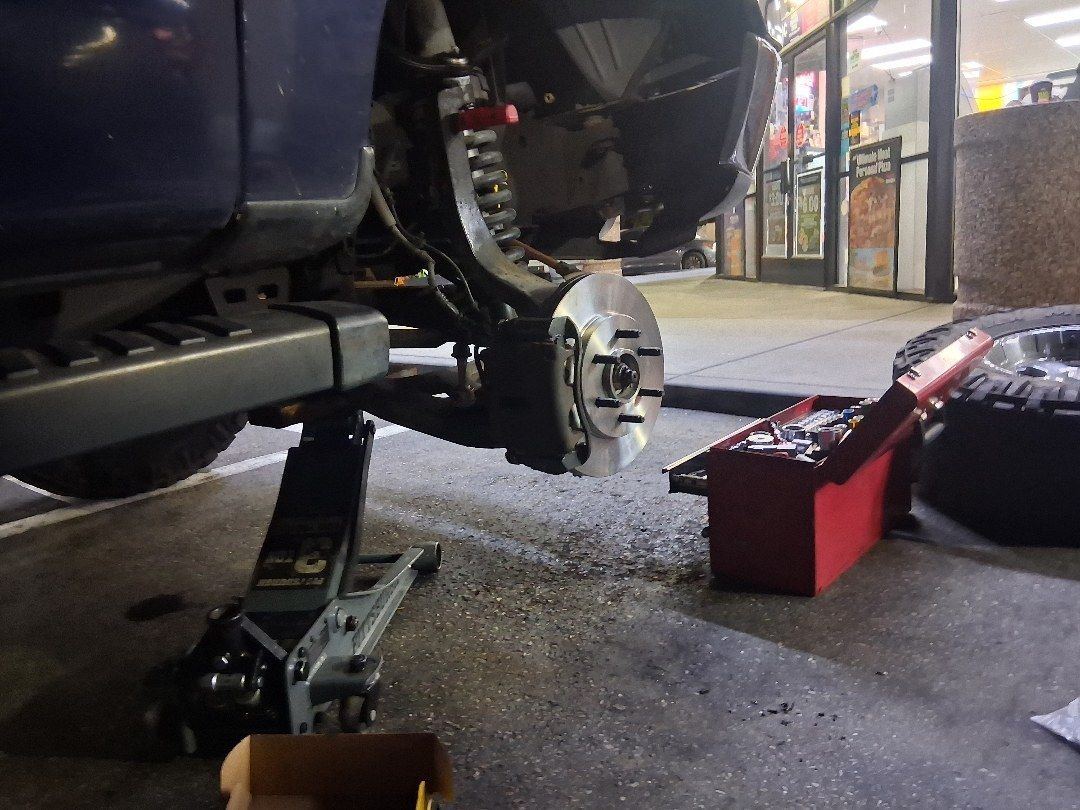 Rotor off. Brake job at night in front of the store.